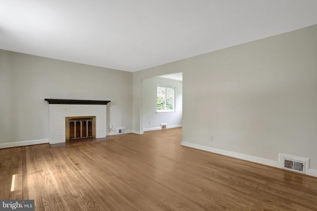 6005 Frederick St, Springfield, VA 22150 - unfurnished living room with wood finished floors and a brick fireplace