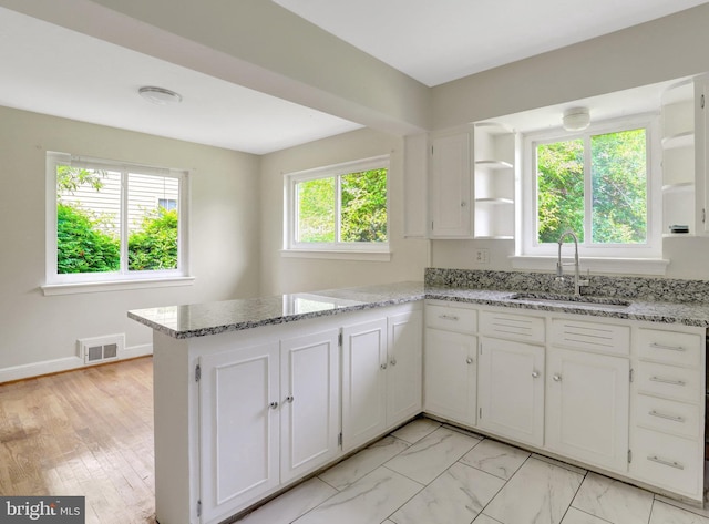 6005 Frederick St, Springfield, VA 22150 - kitchen with open shelves, white cabinets, a peninsula, and light stone counters