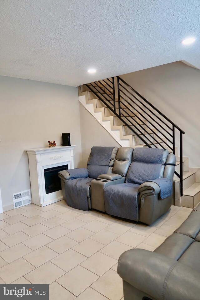 652 E Raymond St, Philadelphia, PA 19120 - living room featuring a textured ceiling, stairs, a fireplace, and recessed lighting