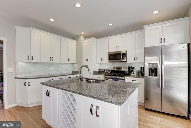 6362 Levtov Lndg, Alexandria, VA 22312 - kitchen with stainless steel appliances, light wood-style floors, decorative backsplash, white cabinets, and dark stone countertops