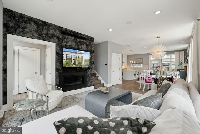 11336 Emerald Park Rd, Potomac, MD 20854 - living area featuring a large fireplace, wood finished floors, a chandelier, recessed lighting, and an accent wall