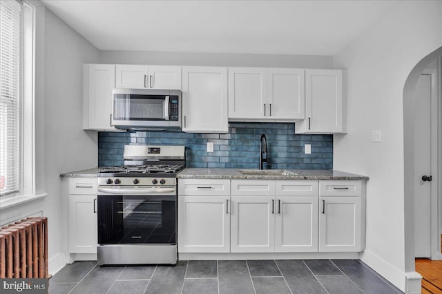 1528 Park Blvd, Camden, NJ 08103 - kitchen featuring appliances with stainless steel finishes, radiator heating unit, arched walkways, and white cabinets