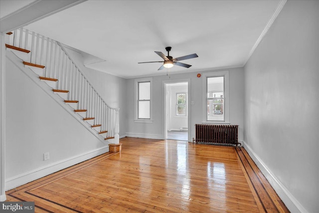 1528 Park Blvd, Camden, NJ 08103 - unfurnished living room featuring radiator heating unit, stairs, hardwood / wood-style floors, a ceiling fan, and ornamental molding
