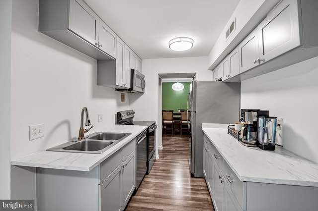 7702 Hanover Pkwy Unit 301, Greenbelt, MD 20770 - kitchen featuring appliances with stainless steel finishes, dark wood-style flooring, gray cabinets, and light stone countertops