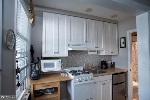 5600 Seaview Ave, Wildwood Crest, NJ 08260 - kitchen with white appliances, under cabinet range hood, white cabinets, and tasteful backsplash