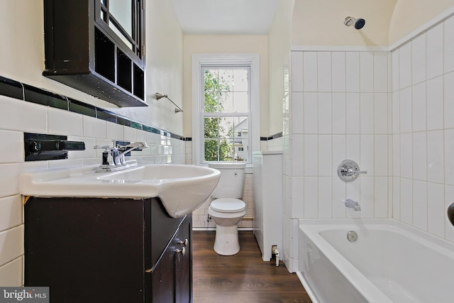 4713 Elsrode Ave, Baltimore, MD 21214 - bathroom with tile walls, vanity, wood finished floors, a wainscoted wall, and tub / shower combination