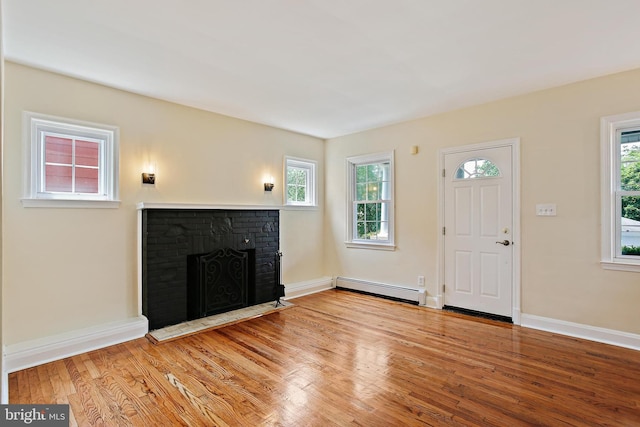 4713 Elsrode Ave, Baltimore, MD 21214 - unfurnished living room featuring baseboard heating, a fireplace, and wood finished floors