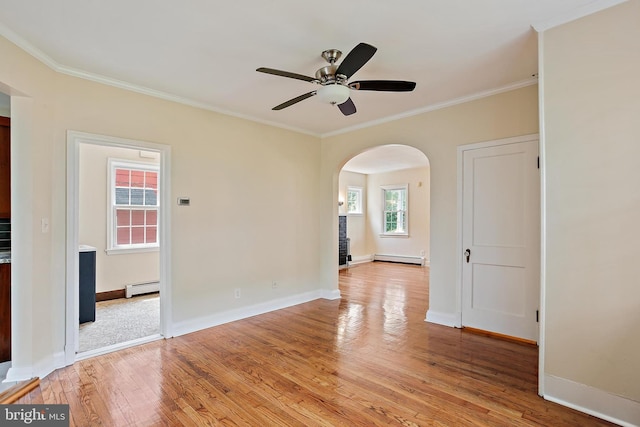4713 Elsrode Ave, Baltimore, MD 21214 - spare room with a baseboard heating unit, arched walkways, crown molding, light wood finished floors, and a ceiling fan