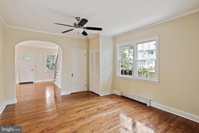 4713 Elsrode Ave, Baltimore, MD 21214 - spare room featuring a baseboard heating unit, arched walkways, light wood-style floors, crown molding, and ceiling fan