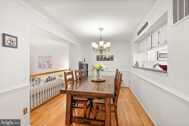 6498 Milva Ln, Springfield, VA 22150 - dining space with light wood-style floors, a chandelier, and ornamental molding