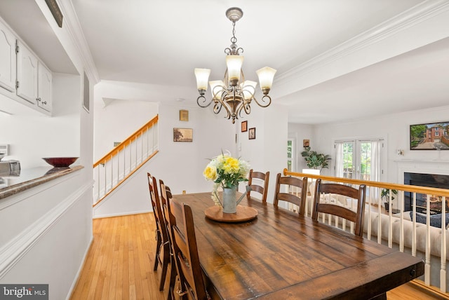 6498 Milva Ln, Springfield, VA 22150 - dining space featuring stairway, light wood-style flooring, crown molding, a chandelier, and a fireplace