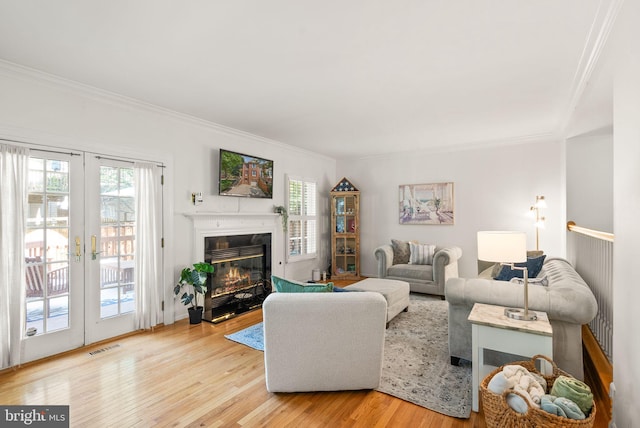6498 Milva Ln, Springfield, VA 22150 - living room with ornamental molding, healthy amount of natural light, light wood-style flooring, a premium fireplace, and french doors
