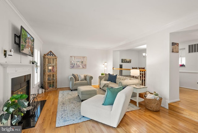 6498 Milva Ln, Springfield, VA 22150 - living area featuring crown molding, wood finished floors, healthy amount of natural light, and a fireplace with flush hearth