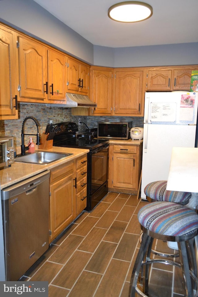 4701 Pennell Rd Unit A-6, Aston, PA 19014 - kitchen featuring stainless steel appliances, light countertops, ventilation hood, decorative backsplash, and brown cabinetry