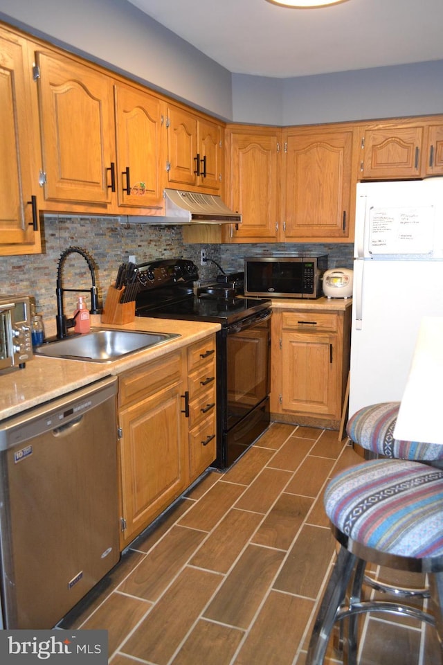4701 Pennell Rd Unit A-6, Aston, PA 19014 - kitchen featuring appliances with stainless steel finishes, wall chimney exhaust hood, light countertops, backsplash, and brown cabinetry