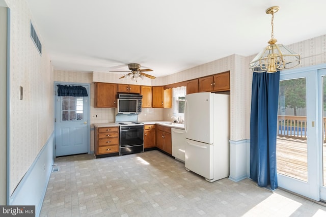 330 N Liberty St, Coopersburg, PA 18036 - kitchen featuring wallpapered walls, white appliances, a chandelier, healthy amount of natural light, and brown cabinets