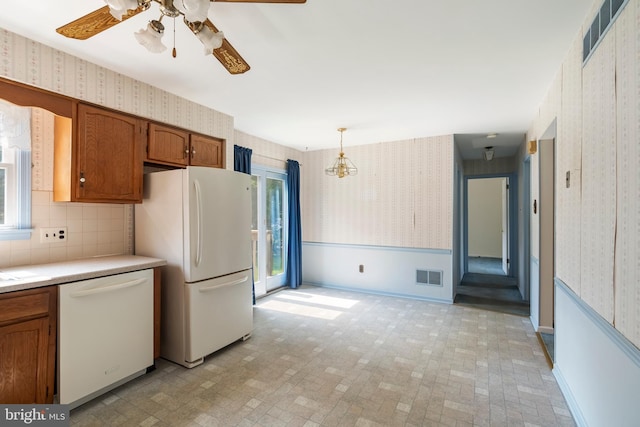 330 N Liberty St, Coopersburg, PA 18036 - kitchen with wallpapered walls, white appliances, a ceiling fan, brown cabinets, and light countertops