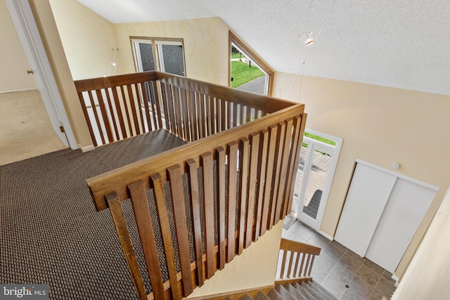 39 Haymarket Ln, Bryn Mawr, PA 19010 - staircase with tile patterned flooring, a textured ceiling, and carpet flooring