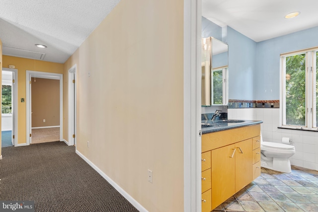 39 Haymarket Ln, Bryn Mawr, PA 19010 - bathroom featuring vanity, tile walls, wainscoting, and a textured ceiling