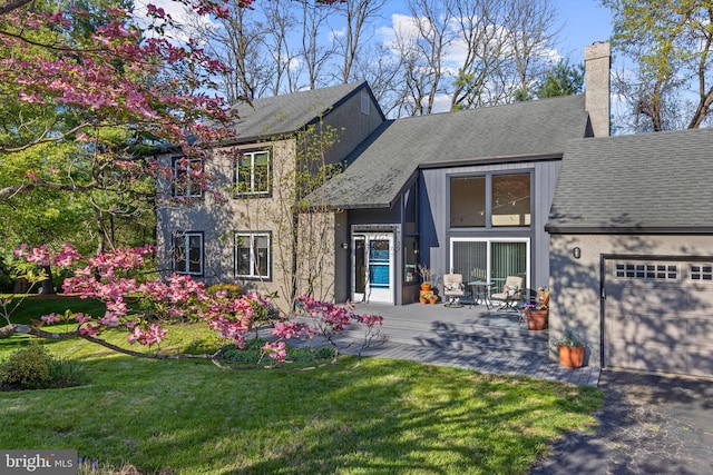 39 Haymarket Ln, Bryn Mawr, PA 19010 - view of front of house with an attached garage, a chimney, a front lawn, and a shingled roof