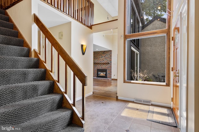 39 Haymarket Ln, Bryn Mawr, PA 19010 - stairs with a high ceiling and a brick fireplace