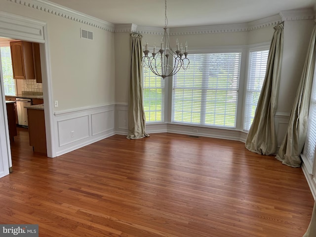 206 Excalibur Dr, Newtown Square, PA 19073 - unfurnished dining area featuring a chandelier, plenty of natural light, wood finished floors, wainscoting, and crown molding