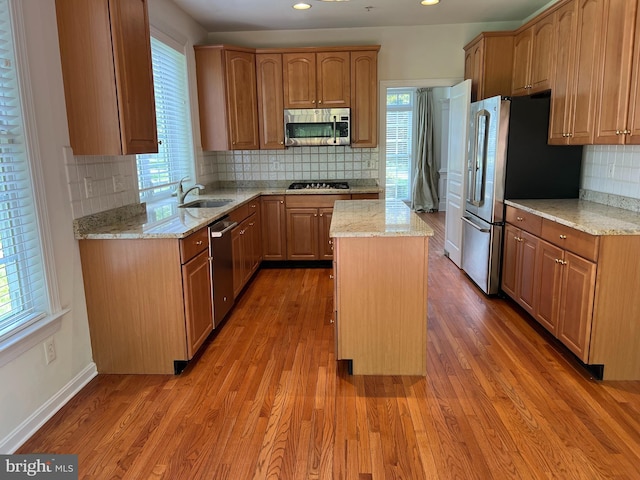 206 Excalibur Dr, Newtown Square, PA 19073 - kitchen with appliances with stainless steel finishes, light wood-style floors, backsplash, a center island, and light stone countertops