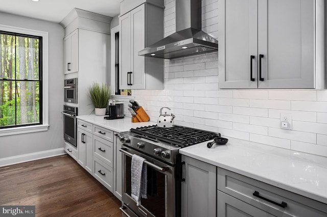 103 Wateredge Ln, Fredericksburg, VA 22406 - kitchen featuring wall chimney range hood, appliances with stainless steel finishes, tasteful backsplash, dark wood finished floors, and gray cabinetry