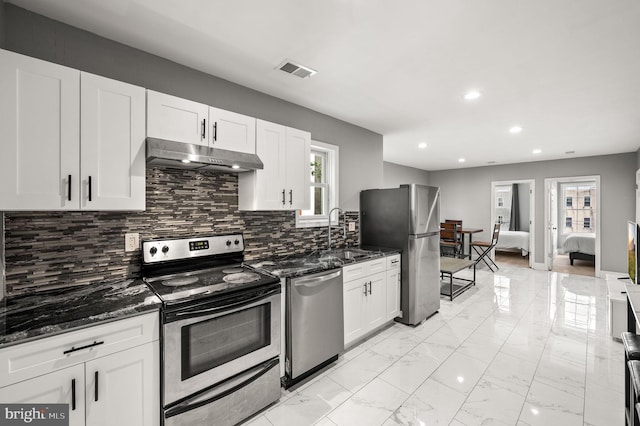 1719 W Norris St, Philadelphia, PA 19121 - kitchen featuring appliances with stainless steel finishes, under cabinet range hood, dark stone countertops, recessed lighting, and white cabinetry
