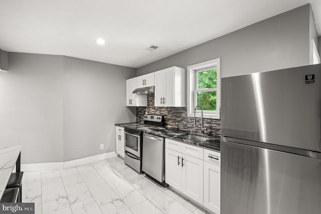 1719 W Norris St, Philadelphia, PA 19121 - kitchen featuring stainless steel appliances, light marble finish flooring, white cabinetry, recessed lighting, and decorative backsplash