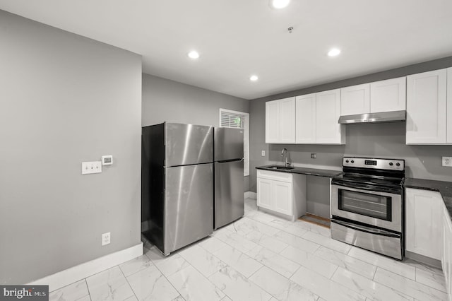 1719 W Norris St, Philadelphia, PA 19121 - kitchen featuring appliances with stainless steel finishes, under cabinet range hood, light marble finish flooring, dark countertops, and recessed lighting