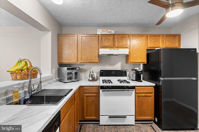 50 Amberstone Ct, Annapolis, MD 21403 - kitchen with freestanding refrigerator, white gas range oven, under cabinet range hood, light countertops, and a textured ceiling