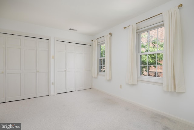 6708 Langston Blvd Unit A, Arlington, VA 22205 - unfurnished bedroom featuring multiple closets, multiple windows, and carpet flooring