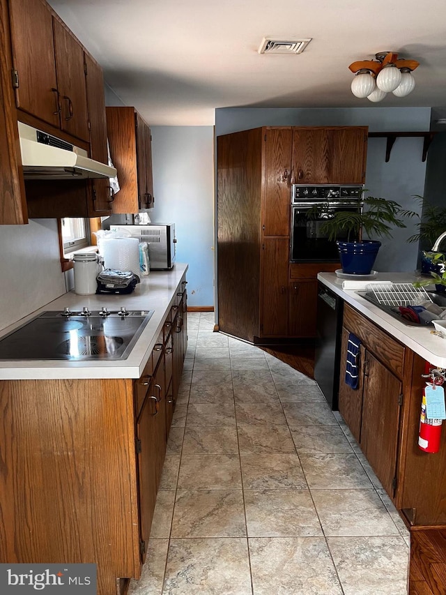 636 Pigeon Creek Rd, Pottstown, PA 19465 - kitchen featuring black appliances, under cabinet range hood, and light countertops
