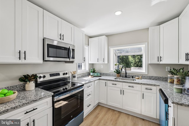 202 Piping Rock Dr, Silver Spring, MD 20905 - kitchen featuring stainless steel appliances, white cabinets, light stone countertops, light wood-style flooring, and recessed lighting