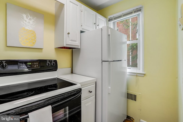 4004 Beecher St NW Unit 304, Washington, DC 20007 - kitchen featuring black electric range oven, freestanding refrigerator, white cabinetry, and light countertops