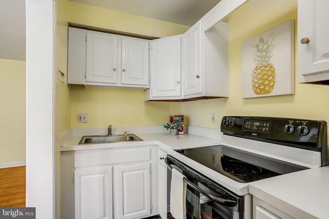 4004 Beecher St NW Unit 304, Washington, DC 20007 - kitchen with electric range oven, white cabinetry, and light countertops