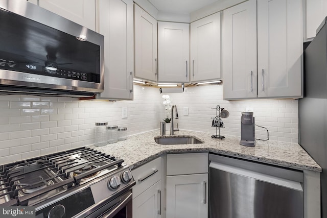 2619 Poplar Dr, Baltimore, MD 21207 - kitchen with stainless steel appliances, decorative backsplash, light stone countertops, and white cabinetry
