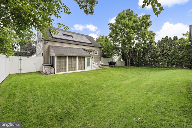 2619 Poplar Dr, Baltimore, MD 21207 - rear view of property featuring a gate, a sunroom, roof mounted solar panels, a fenced backyard, and a shingled roof