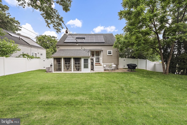 2619 Poplar Dr, Baltimore, MD 21207 - rear view of house featuring a sunroom, a shingled roof, solar panels, and a fenced backyard