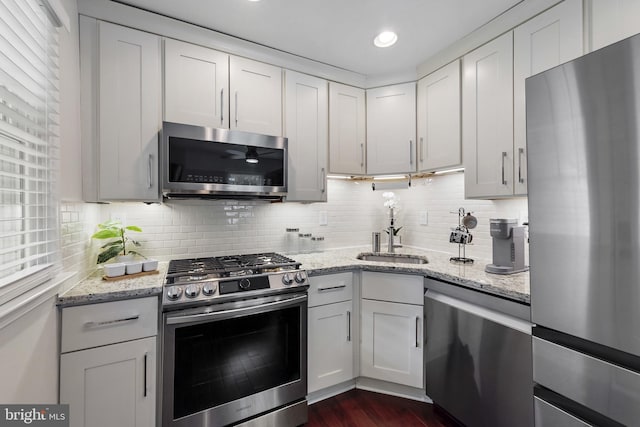 2619 Poplar Dr, Baltimore, MD 21207 - kitchen featuring stainless steel appliances, backsplash, light stone countertops, white cabinetry, and dark wood-type flooring
