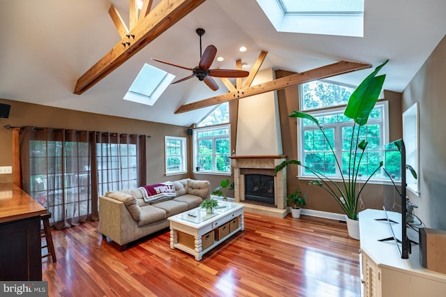 496 Black Swan Ln, Berwyn, PA 19312 - living room with a skylight, a ceiling fan, light wood finished floors, a tile fireplace, and beam ceiling