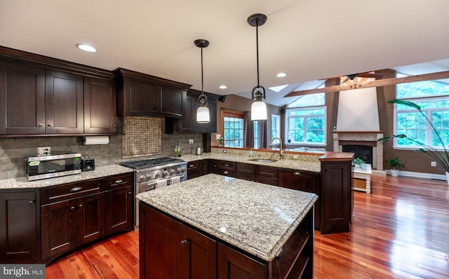 496 Black Swan Ln, Berwyn, PA 19312 - kitchen with stainless steel appliances, a peninsula, light wood-style flooring, a fireplace with raised hearth, and a ceiling fan