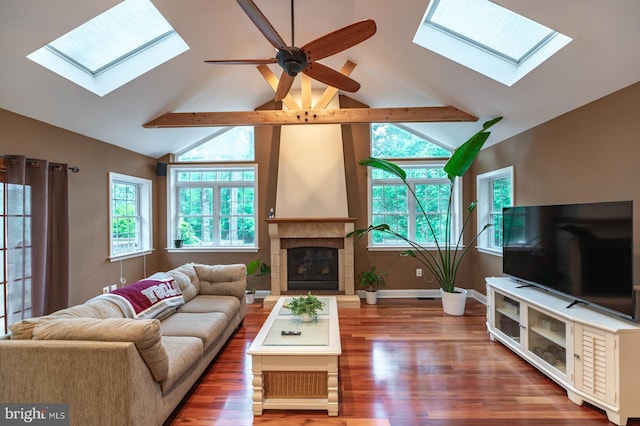 496 Black Swan Ln, Berwyn, PA 19312 - living room with a skylight, wood finished floors, a ceiling fan, a tiled fireplace, and beam ceiling