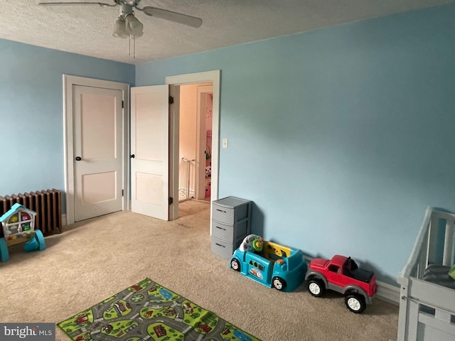 433 Williams St, Cumberland, MD 21502 - recreation room featuring radiator heating unit, carpet floors, a ceiling fan, and a textured ceiling