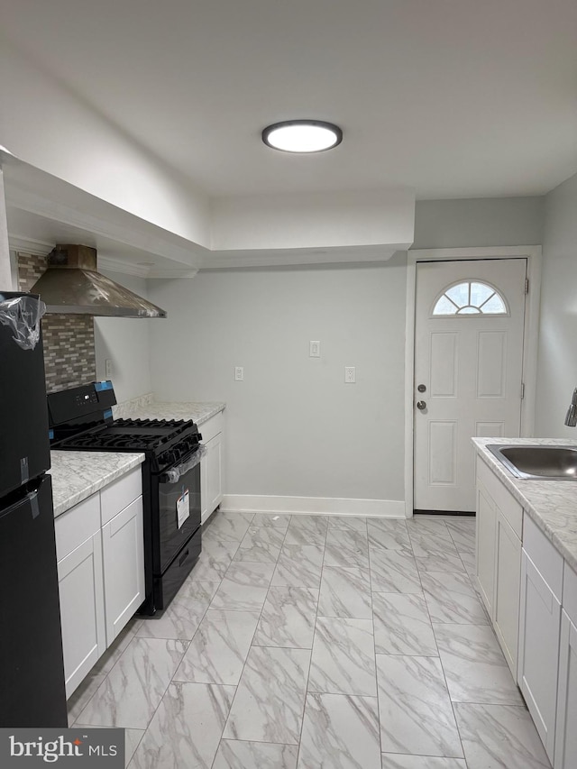 1447 S 28th St, Philadelphia, PA 19146 - kitchen featuring black appliances, wall chimney exhaust hood, light marble finish flooring, white cabinetry, and light stone counters