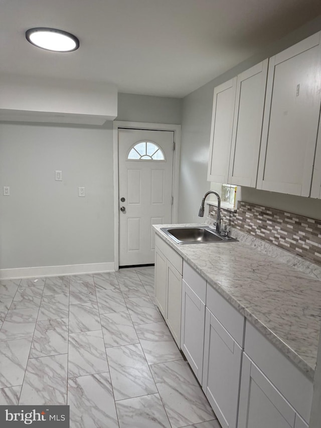 1447 S 28th St, Philadelphia, PA 19146 - kitchen featuring light marble finish floors, white cabinetry, and decorative backsplash