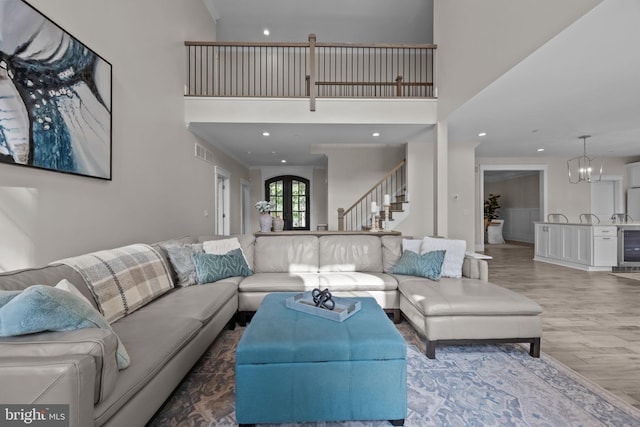 4245 Mechanicsville Rd, Doylestown, PA 18902 - living area with a towering ceiling, beverage cooler, wood finished floors, stairs, and a chandelier