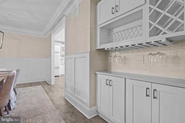 4245 Mechanicsville Rd, Doylestown, PA 18902 - bar area with ornamental molding, light wood-type flooring, wainscoting, and decorative backsplash