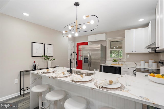 105 Concove Way, Havre De Grace, MD 21078 - kitchen with stainless steel fridge, a kitchen bar, wood finished floors, a peninsula, and white cabinetry